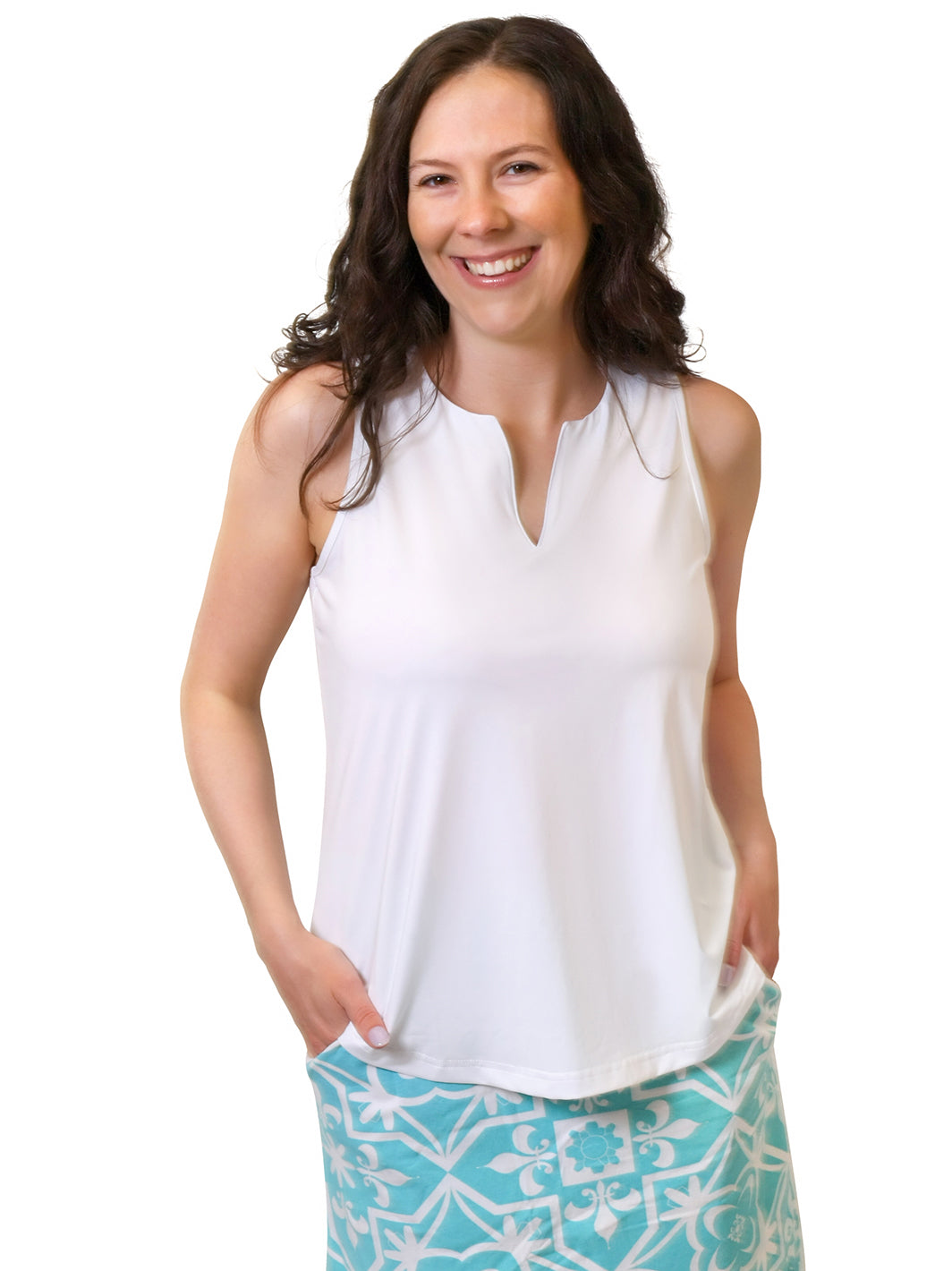 Woman wearing a white sleeveless top with a notched neckline and an aqua tile-print skort with pockets